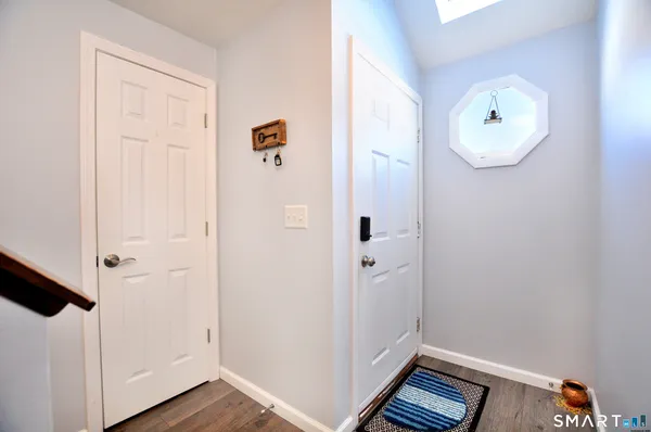 a view of a hallway with wooden floor and closet