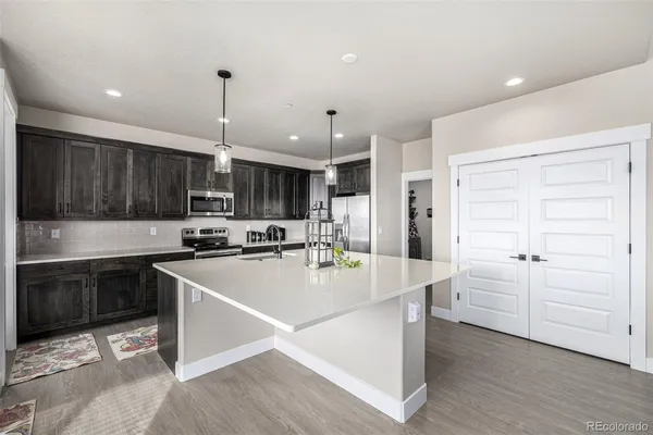 a kitchen with kitchen island a stove a sink and a refrigerator