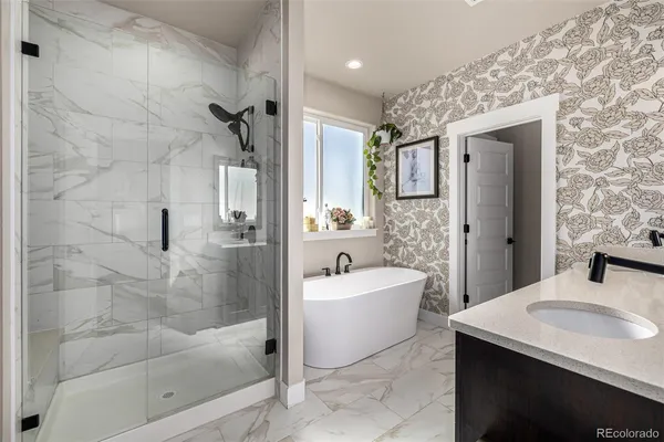 a bathroom with a bathtub shower sink mirror and toilet