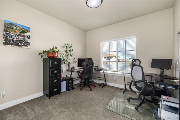 a view of a workspace with furniture and a window