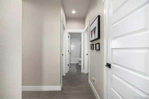 a view of a hallway with wooden floor and entryway