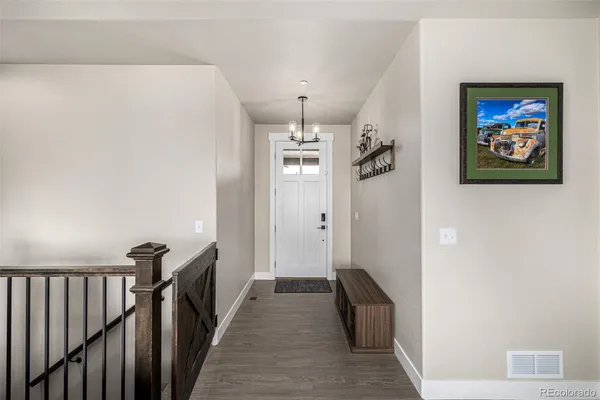 a view of a hallway with wooden floor and staircase