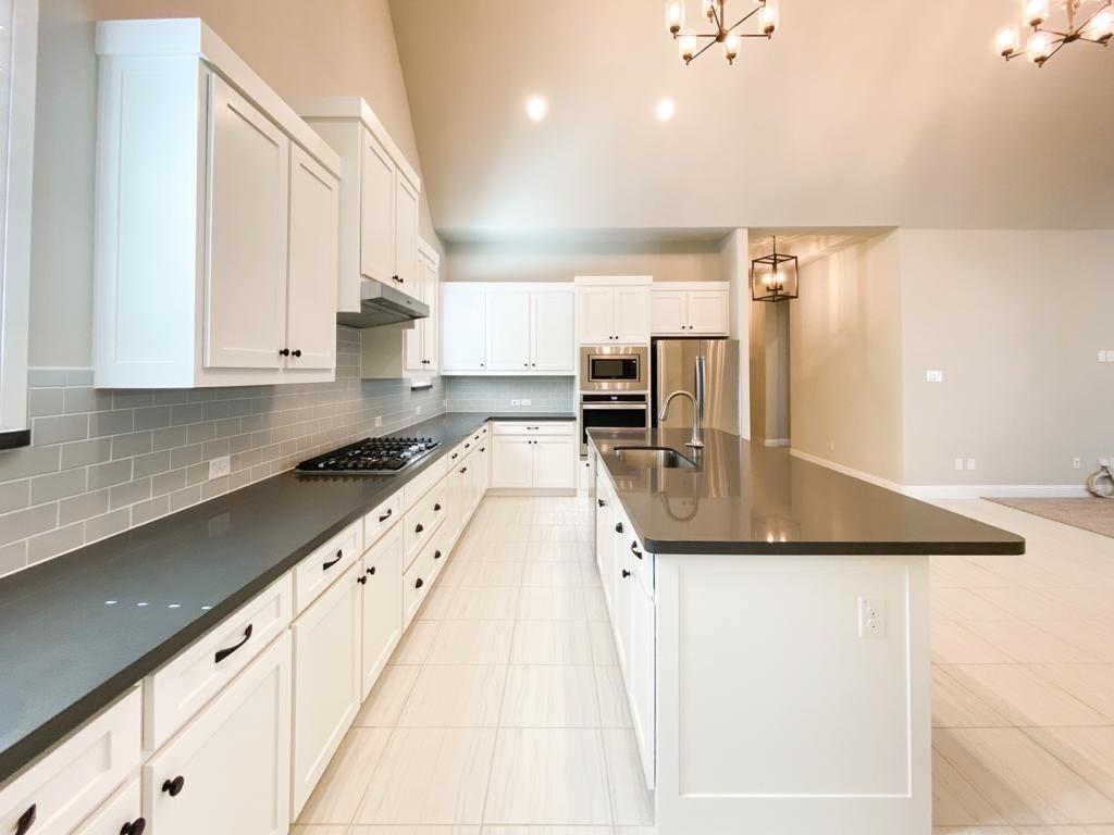 a kitchen with stainless steel appliances granite countertop a sink a stove and cabinets