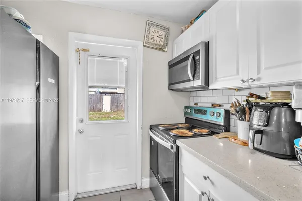 a kitchen with stainless steel appliances granite countertop a refrigerator a stove a sink and a microwave