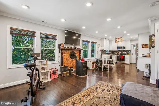 a living room with furniture pool table wooden floor and a large window