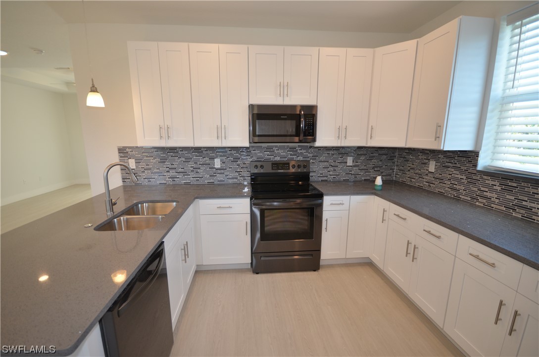 8581 Agate Street Port Charlotte, FL 33981 - Photo 20 of 50 a kitchen with granite countertop white cabinets and stainless steel appliances