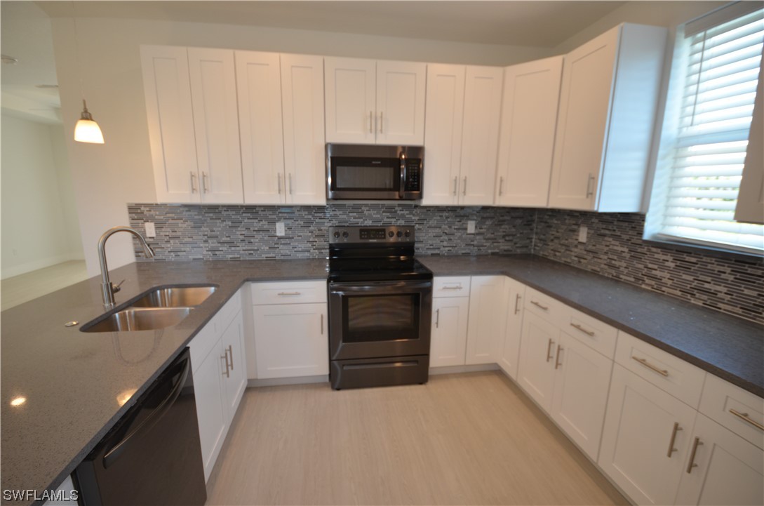 8581 Agate Street Port Charlotte, FL 33981 - Photo 22 of 50 a kitchen with granite countertop white cabinets and stainless steel appliances