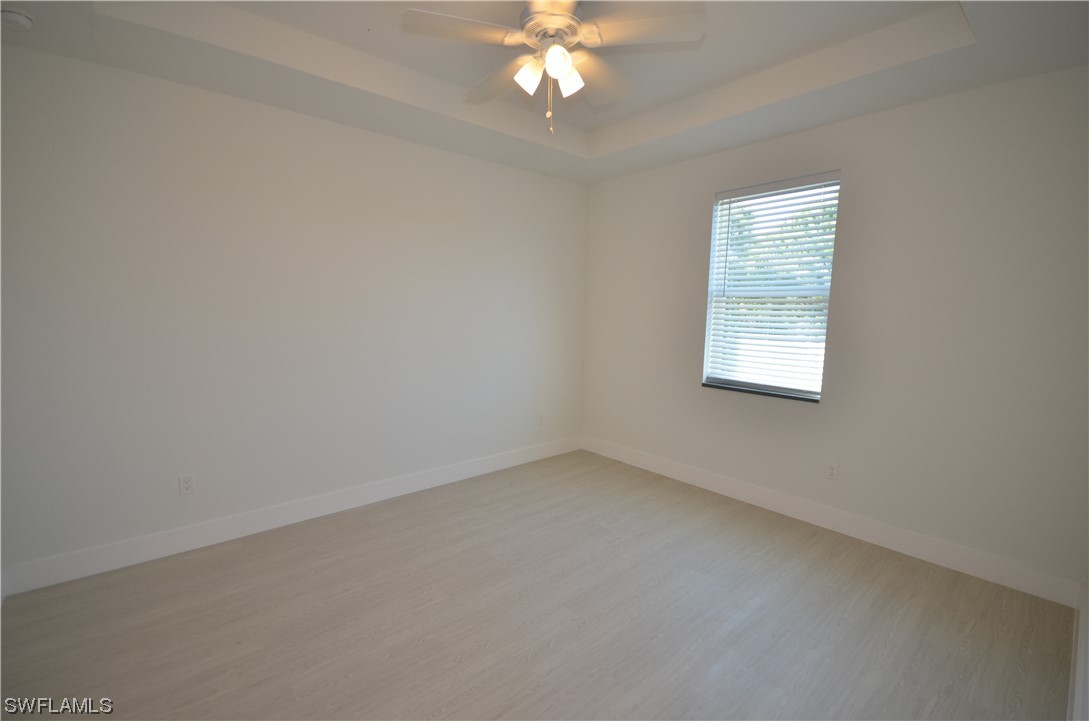 8581 Agate Street Port Charlotte, FL 33981 - Photo 32 of 50 an empty room with a chandelier fan and windows