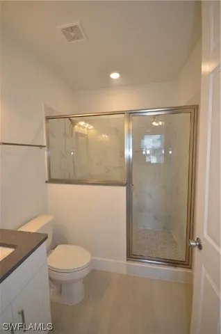 a bathroom with a granite countertop sink mirror vanity and toilet