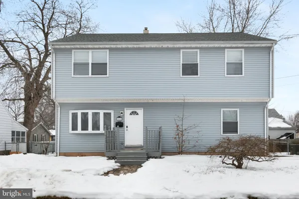 a front view of a house with a yard covered in snow