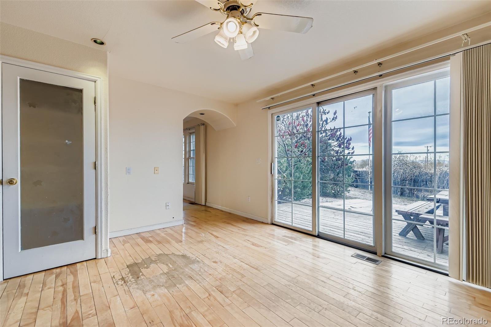 213 Elizabeth Court Fort Lupton, CO 80621 - Photo 12 of 27 a view of an empty room with wooden floor and a window