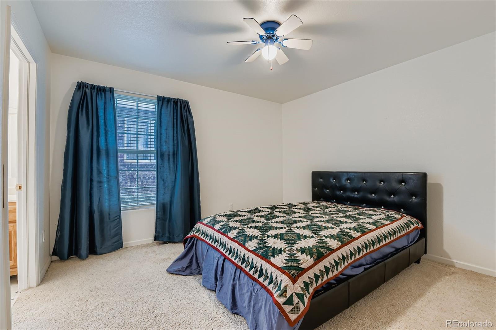 213 Elizabeth Court Fort Lupton, CO 80621 - Photo 20 of 27 a bedroom with a bed and a chandelier