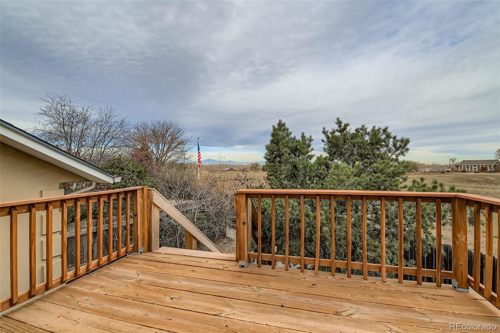 213 Elizabeth Court Fort Lupton, CO 80621 - Photo 26 of 27 a balcony with wooden floor and fence