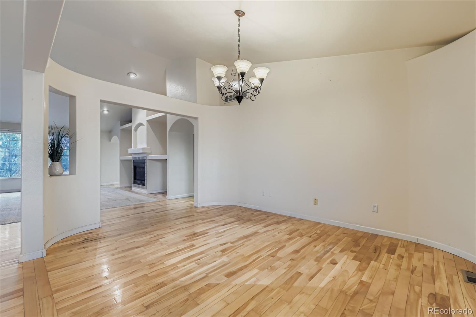 213 Elizabeth Court Fort Lupton, CO 80621 - Photo 4 of 27 a view of a room with a chandelier fan and wooden floor