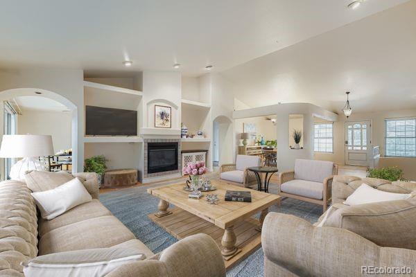213 Elizabeth Court Fort Lupton, CO 80621 - Photo 8 of 27 a living room with furniture a fireplace and a flat screen tv