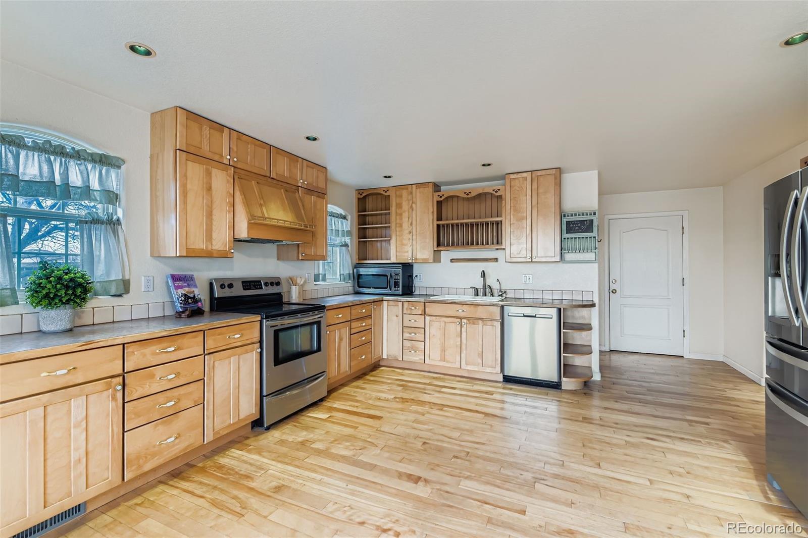 213 Elizabeth Court Fort Lupton, CO 80621 - Photo 10 of 27 a large kitchen with stainless steel appliances granite countertop a stove a sink and white cabinets