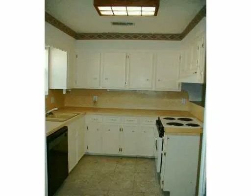 a view of a kitchen with white cabinets