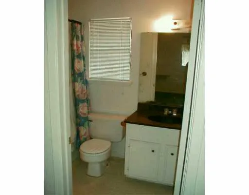 a bathroom with a granite countertop toilet a sink and a mirror