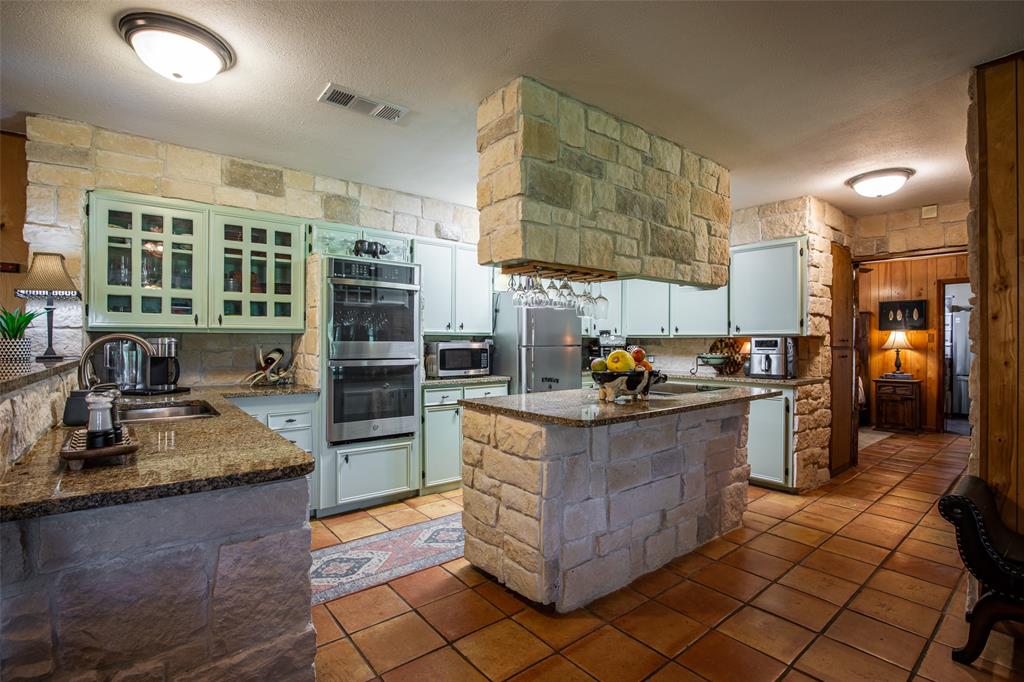 2043 Huddleston Road Sunset, TX 76270 - Photo 10 of 36 a kitchen with stainless steel appliances granite countertop a stove and a refrigerator
