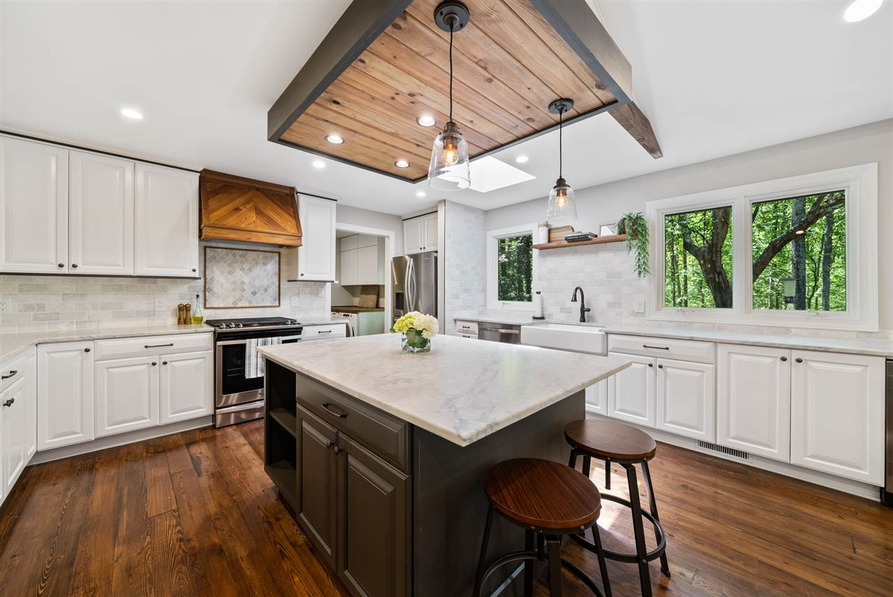 a kitchen with stainless steel appliances granite countertop a stove a sink dishwasher and a refrigerator with wooden floor