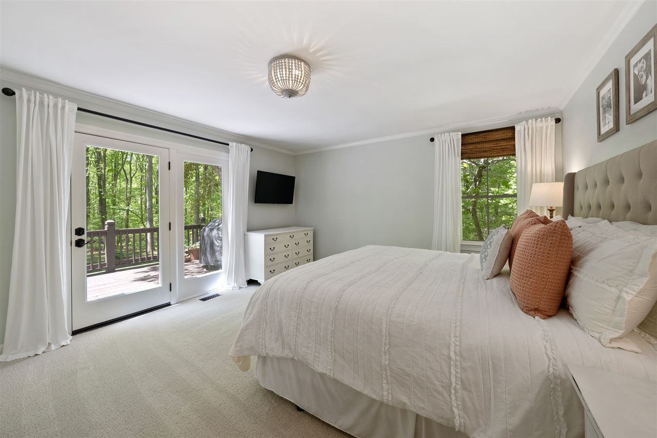 9421 Barton Creek Road Raleigh, NC 27615 - Photo 10 of 30 a bedroom with a large bed and a tv