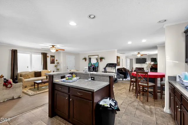 a living room with furniture kitchen view and a large window