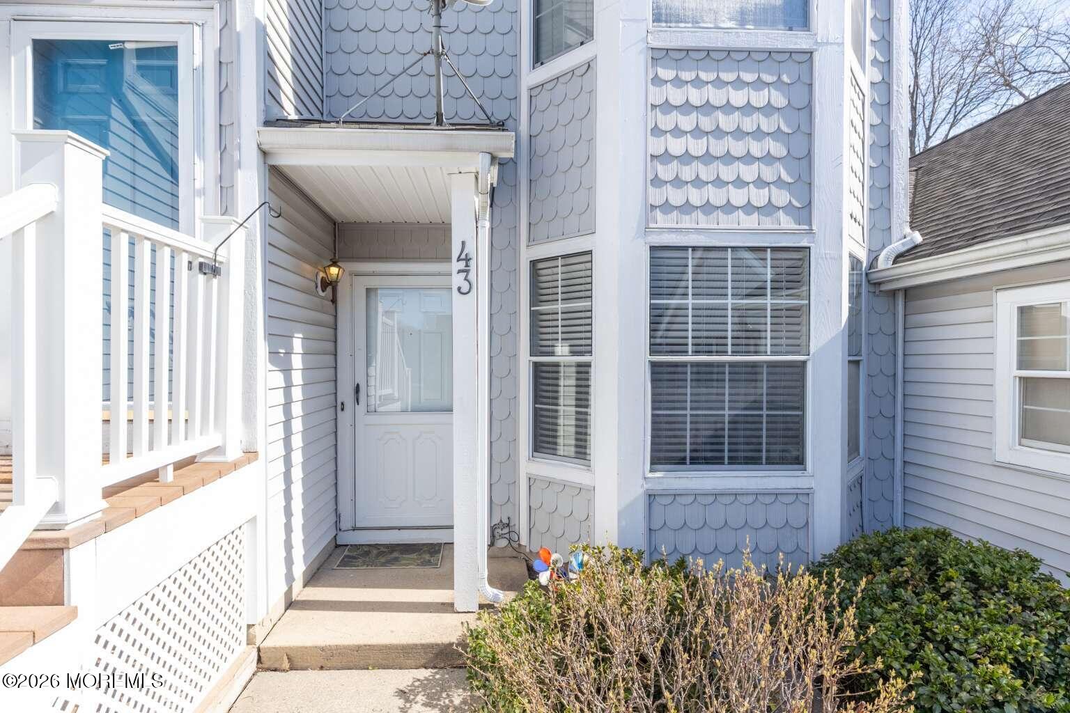 a view of a house with a large window and wooden fence