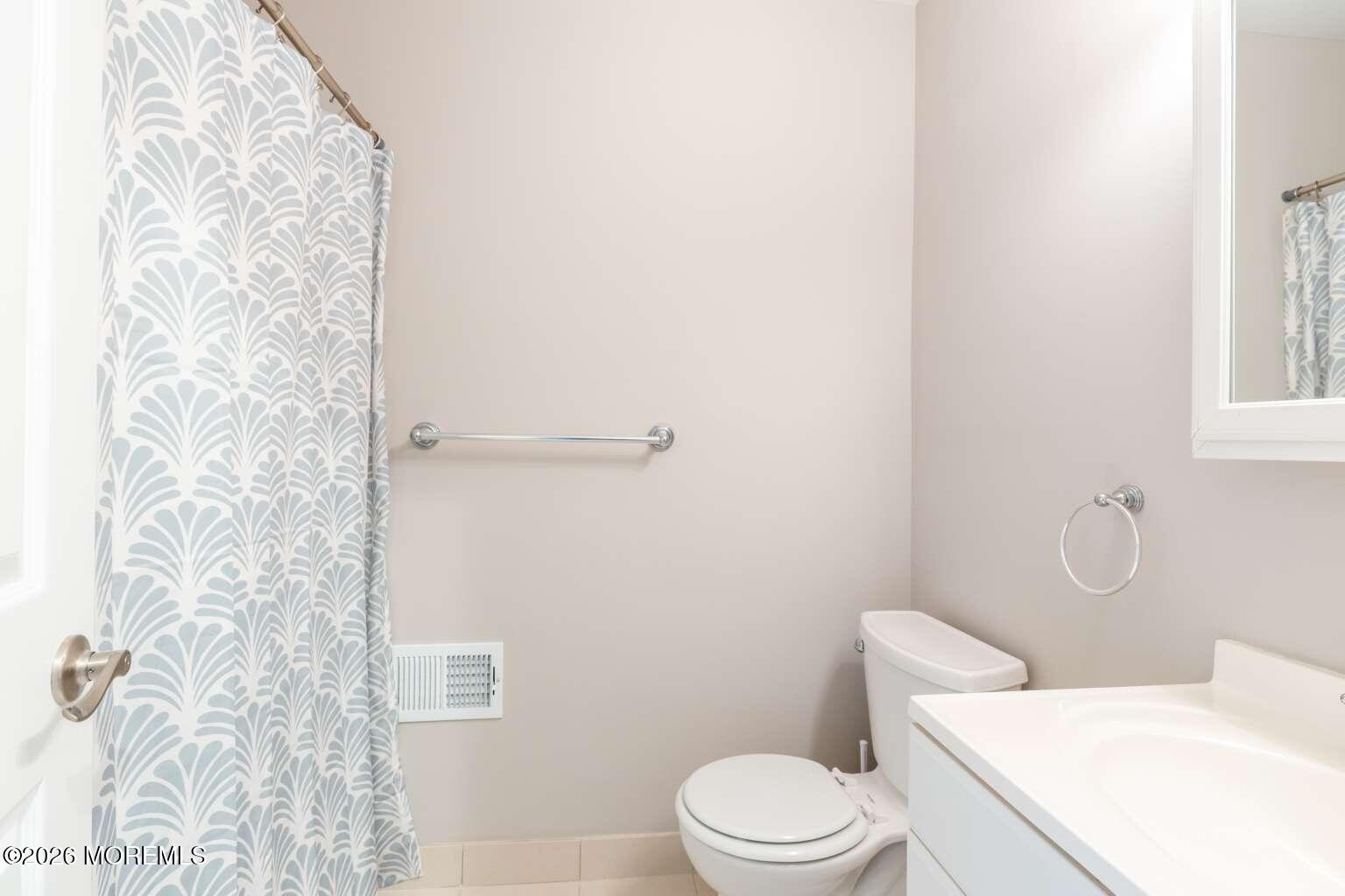 43 Poplar Place Freehold, NJ 07728 - Photo 15 of 31 a white toilet sitting next to a shower curtain