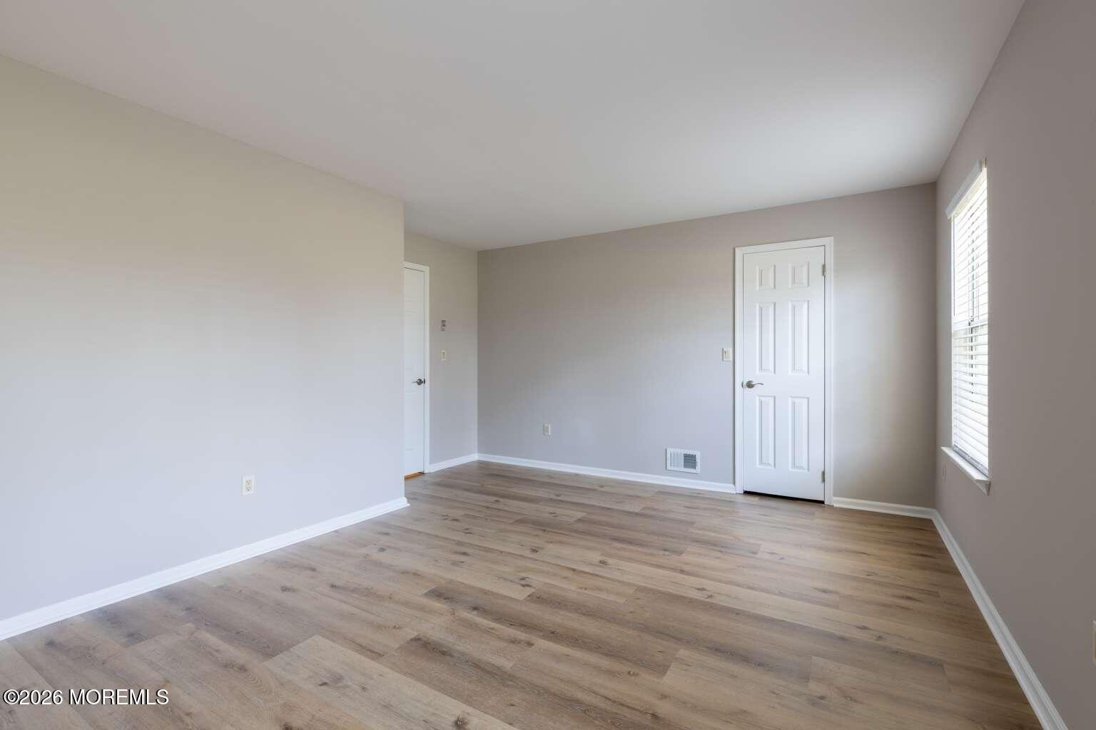43 Poplar Place Freehold, NJ 07728 - Photo 5 of 31 a view of an empty room with wooden floor and window