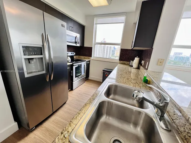 a kitchen with stainless steel appliances granite countertop a refrigerator and a sink