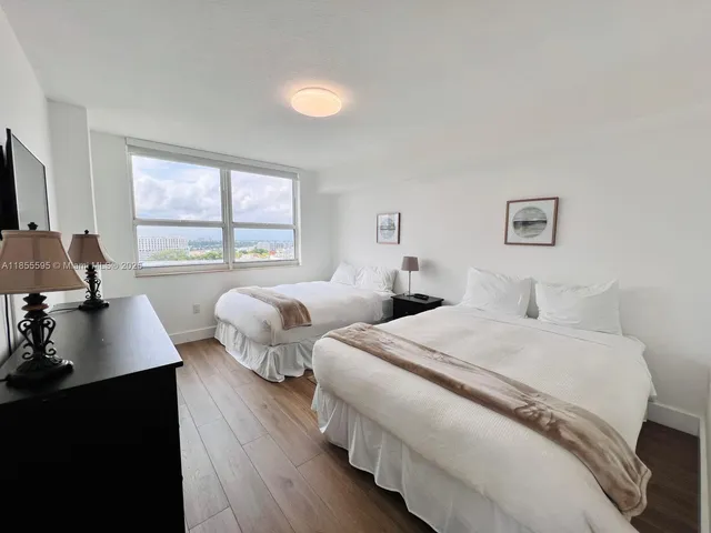 a bedroom with two beds and a large window