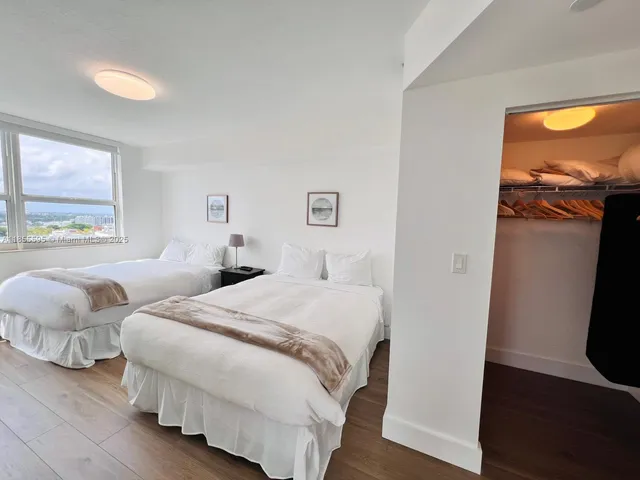 a bedroom with two beds and painting on the wall