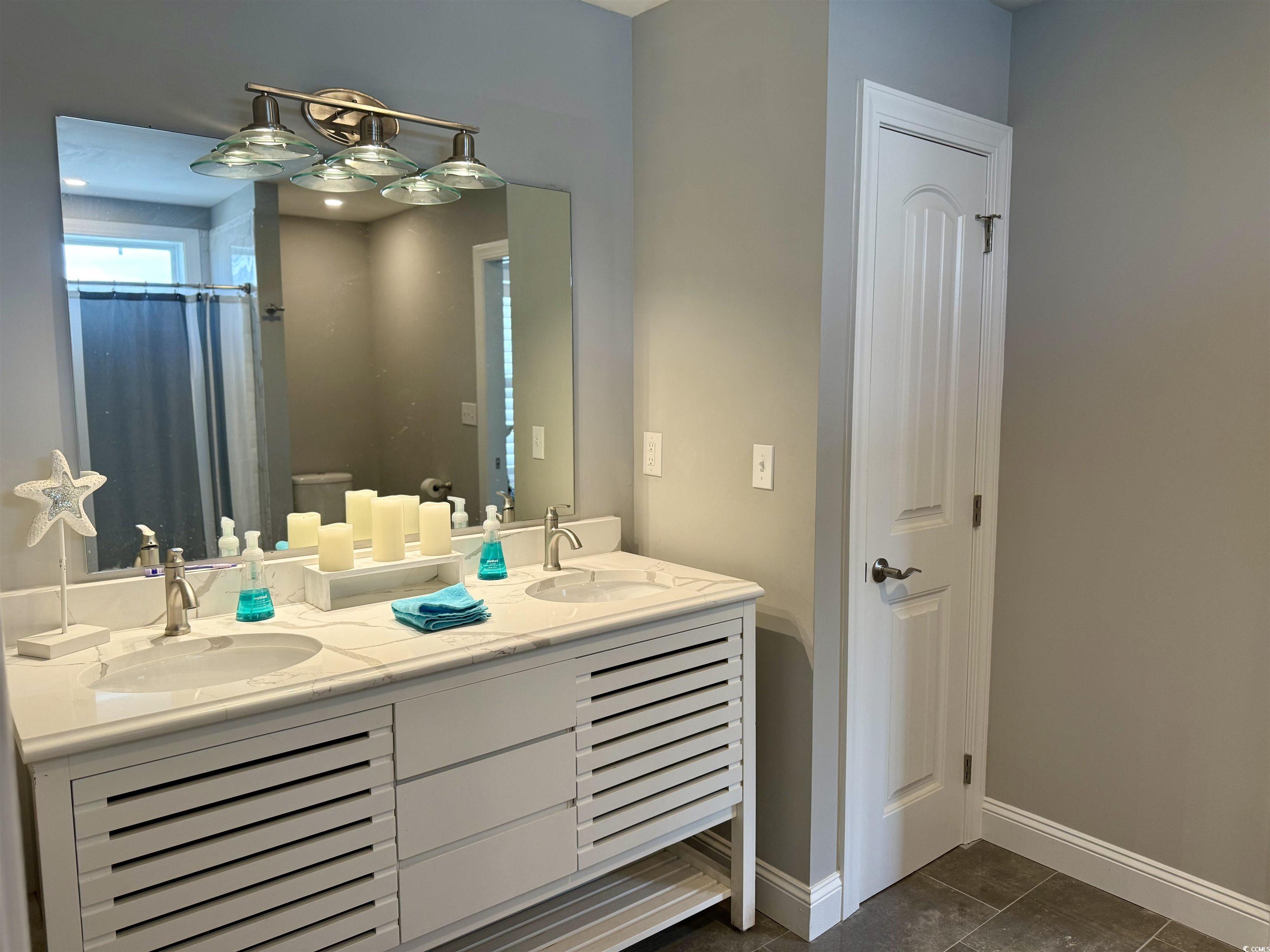 100 Oak Bay Drive Georgetown, SC 29440 - Photo 22 of 33 Bathroom with dark tile patterned floors, double vanity, and a shower with curtain