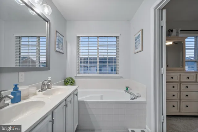 a bathroom with a bathtub a sink a vanity and a window