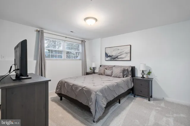 a spacious bedroom with a bed and a flat screen tv