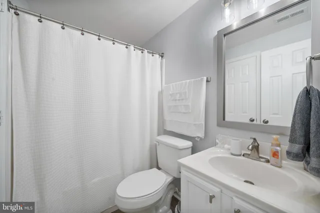 a bathroom with a sink a toilet and shower curtain
