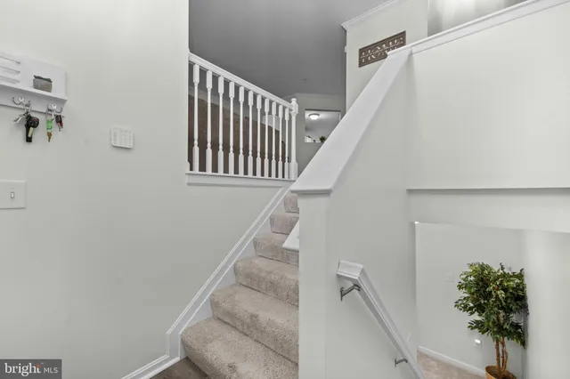 a view of staircase with white walls and a window