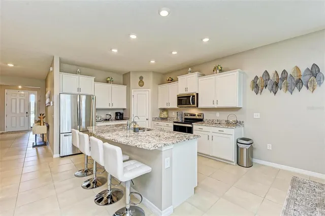 a kitchen with granite countertop white cabinets and refrigerator