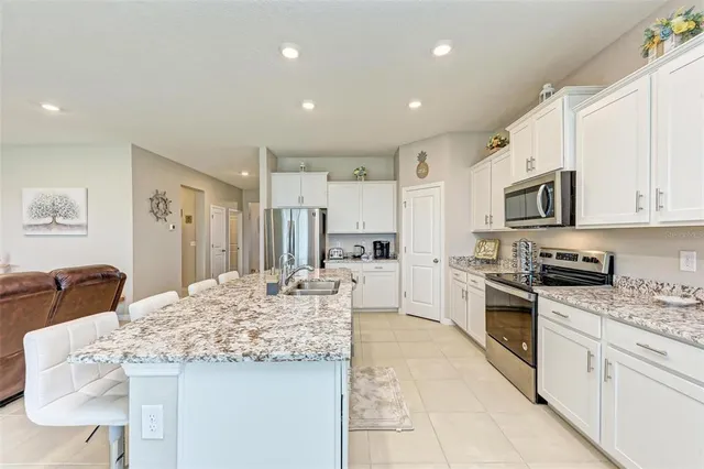 a open kitchen with stainless steel appliances kitchen island granite countertop a sink and cabinets