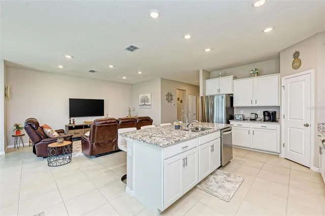 a large kitchen with kitchen island a sink table and chairs