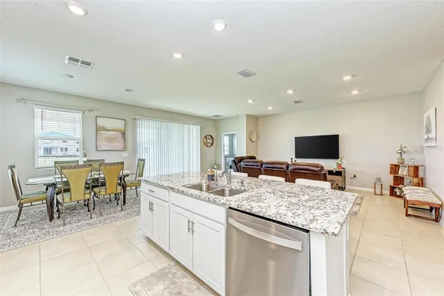 a living room with lots of furniture and view of kitchen