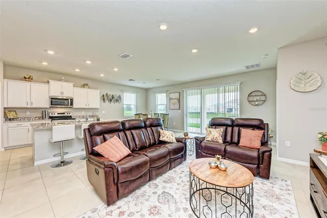 a kitchen with stainless steel appliances kitchen island granite countertop a refrigerator and a stove top oven