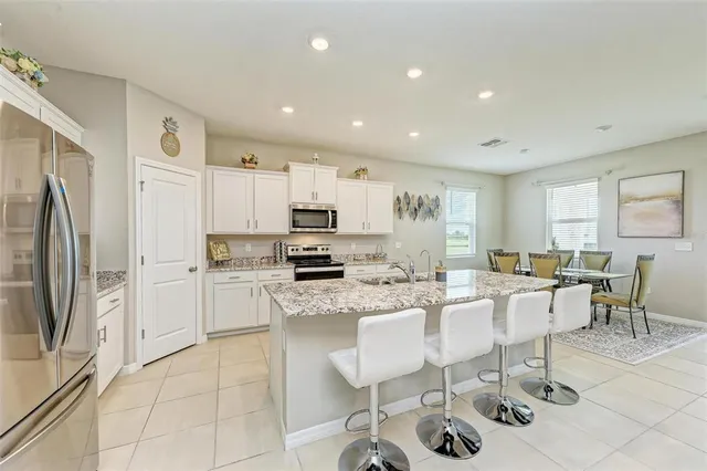 a kitchen with stainless steel appliances kitchen island granite countertop a refrigerator and microwave
