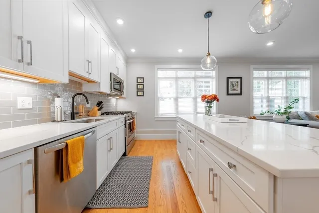 a large kitchen with stainless steel appliances granite countertop a sink and dishwasher a stove a oven with wooden floors