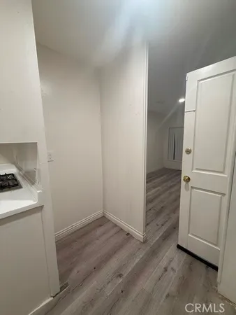 a view of a kitchen with a sink refrigerator and wooden floor