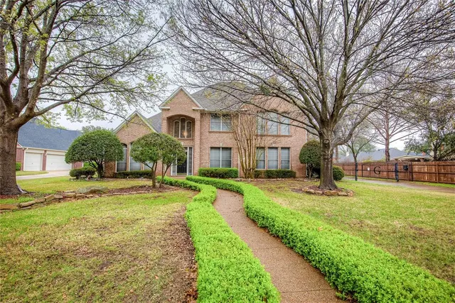 a brick house with trees in front of it