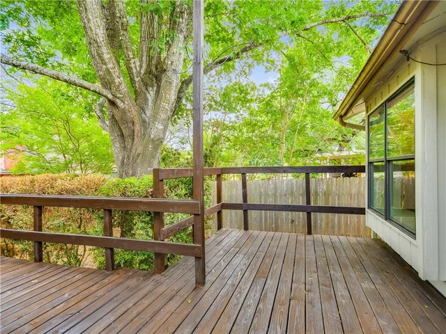 a view of roof deck with wooden floor and fence