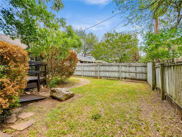 a view of backyard with wooden fence