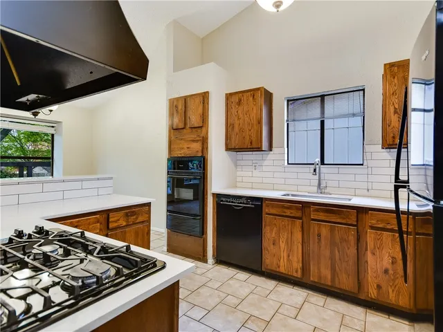 a kitchen with wooden cabinets and a stove top oven