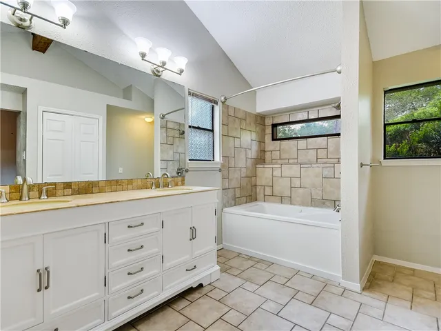 a bathroom with a sink a large mirror and a bathtub